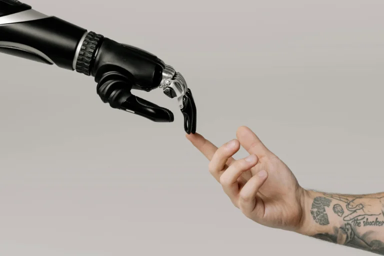 Robotic hand reaching out to touch a human hand, symbolizing AI and human connection.